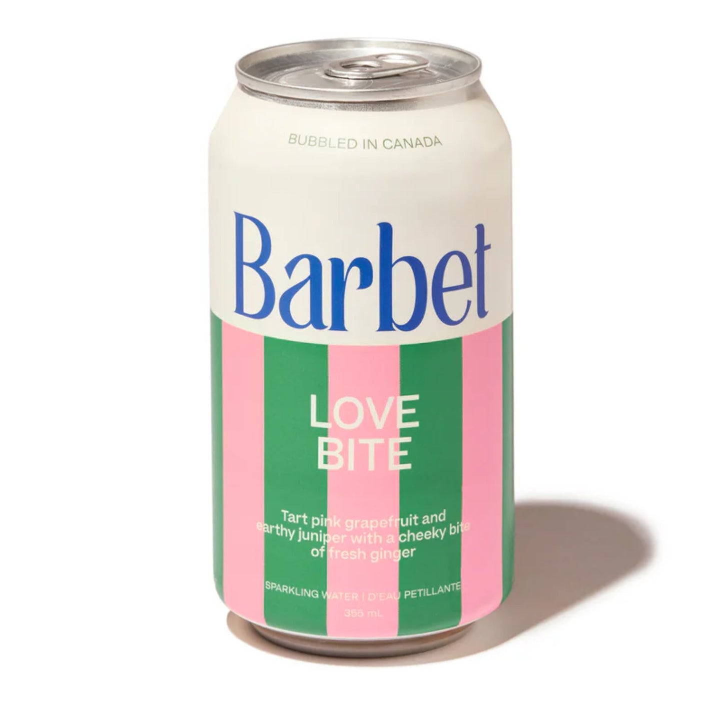 Close-up product shot of a single 355 mL can of Barbet Love Bite non alcoholic sparkling water on a white background. The can features a distinctive bold pink and green vertical stripe design with a white top and the flavor description: "Tart pink grapefruit and earthy hibiscus with a spicy bite of fresh ginger." Bubbled in Canada. Available at Knyota Drink in Ottawa.