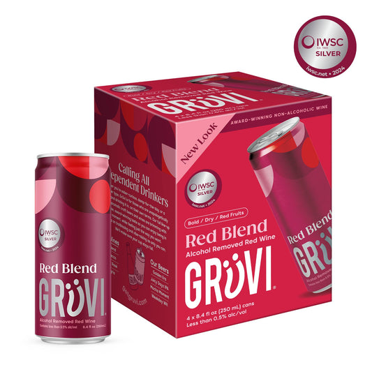 A four-pack box of Grüvi Red Blend non-alcoholic wine cans. The box is predominantly red, with a pattern of dark red and light pink circles, and features a large "Grüvi" logo and "Red Blend" text. A single can is shown in front of the box. Both the can and the box display an "IWSC SILVER 2024" award graphic. The box states "Award-winning non-alcoholic wine" and provides product details such as "4 x 8.4 fl oz (250 mL) cans" and "Less than 0.5% alc/vol." The background is white.