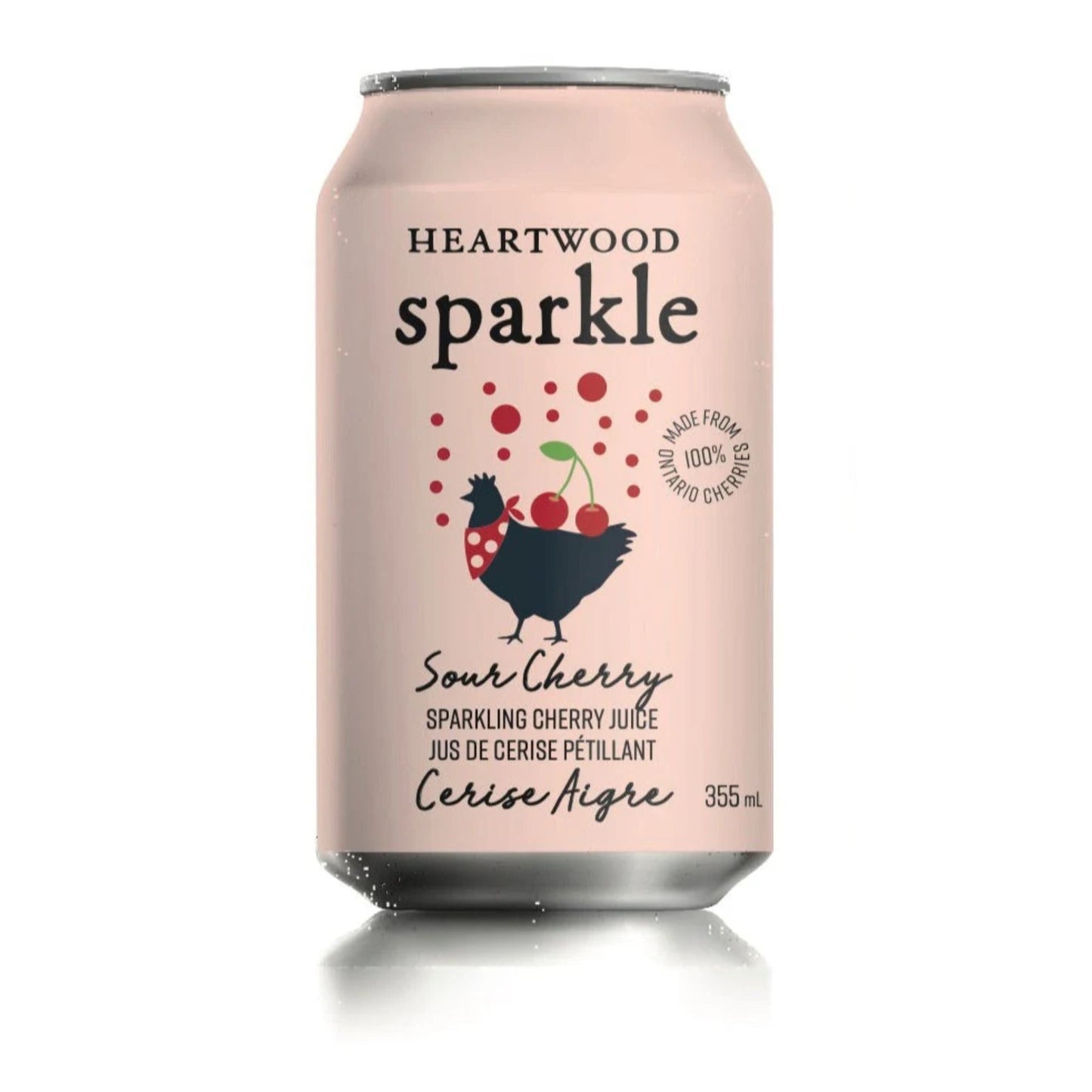 A pastel pink aluminum can labeled “HEARTWOOD Sparkle Sour Cherry” is centered on a plain white background. The design is simple and modern, featuring black text and a playful illustration. Red bubbles rise above a black chicken wearing a red polka-dot scarf, balancing two red cherries with a green stem. A circular stamp reads “MADE FROM 100% ONTARIO CHERRIES.” Lower text describes sparkling cherry juice in English and French, with “355 mL” indicating the volume.