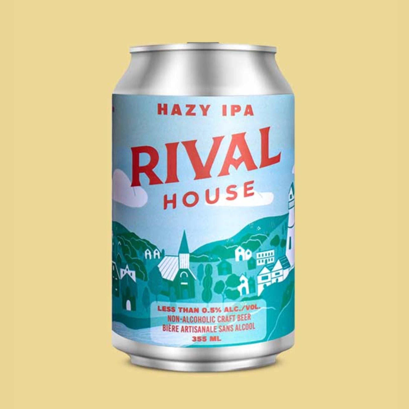 A silver can of Rival House Hazy IPA against a pale yellow background. The can's label is light blue and features a whimsical, light-toned village scene with buildings and a lighthouse. "RIVAL HOUSE" is printed in large red letters at the top, and "HAZY IPA" is written in red above it. The bottom of the label has text that reads "LESS THAN 0.5% ALC./VOL. NON-ALCOHOLIC CRAFT BEER" and "BIÈRE ARTISANALE SANS ALCOOL" along with "355 ML".