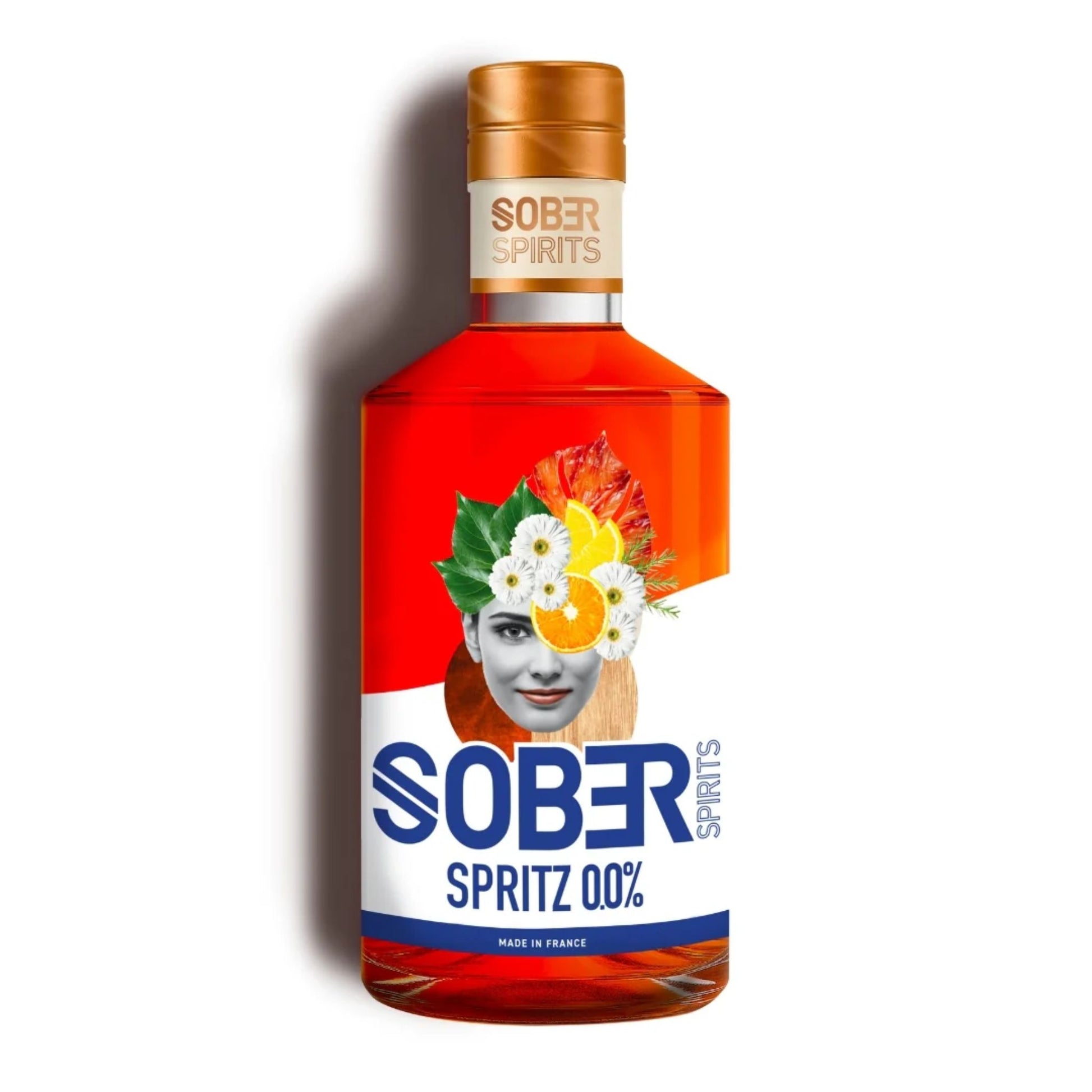 A red bottle of Sober Spirits Spritz 0.0% with a gold cap and a white label. The label features a woman's face surrounded by white flowers and slices of orange and grapefruit. "SOBER SPIRITS" is written in gold at the top of the label, and in larger blue letters at the bottom, "SOBER SPRITZ 0.0%" with "SPIRITS" vertically alongside it. "MADE IN FRANCE" is printed at the very bottom. The bottle casts a shadow on a white background.