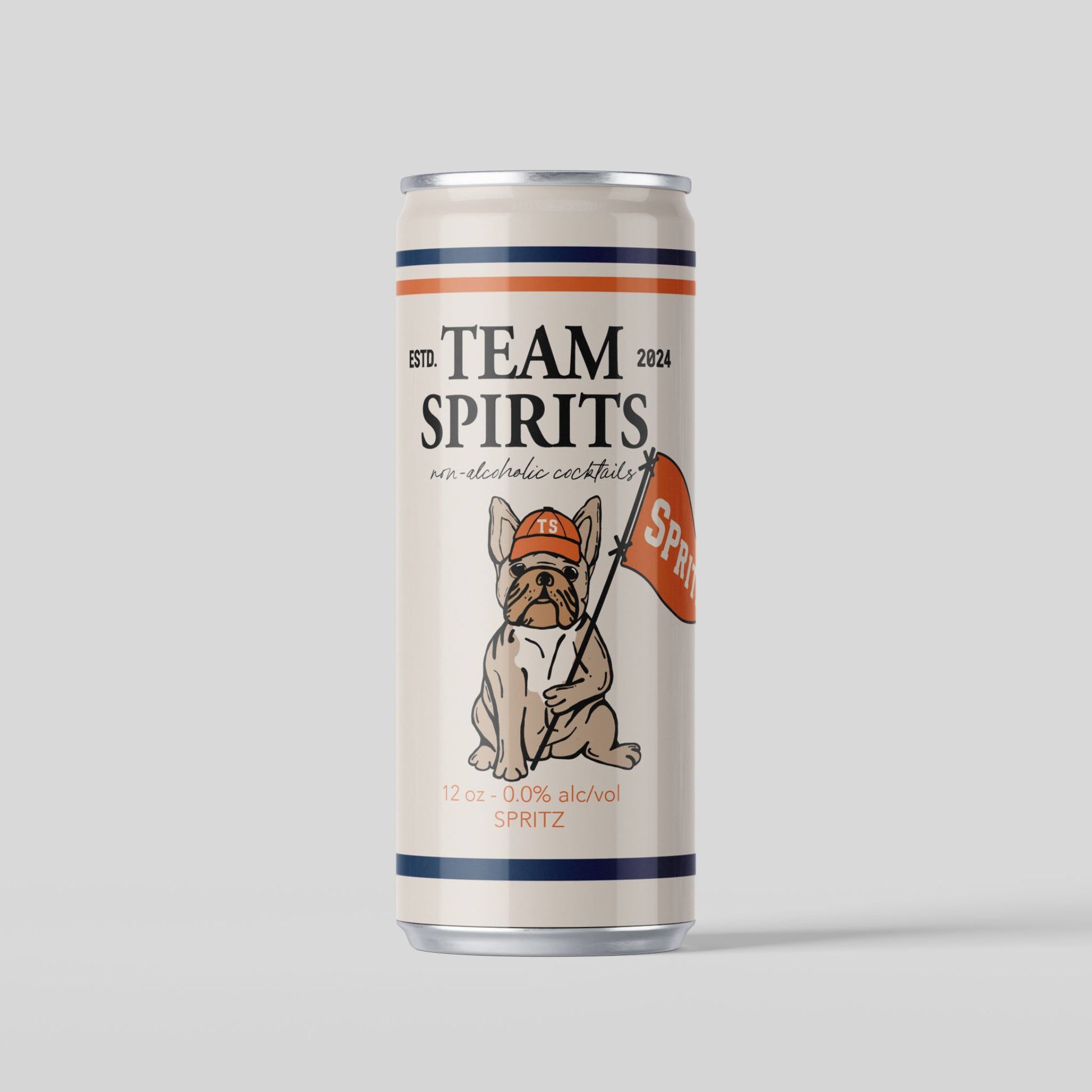 A can of Team Spirits non-alcoholic spritz. The can is cream-colored with dark blue and orange horizontal stripes at the top and bottom. The center of the can features an illustration of a bulldog wearing an orange baseball cap and holding a flag that says "SPRITZ". The text "TEAM SPIRITS" is at the top of the can, with "non-alcoholic cocktails" below it. The can also specifies "12 oz - 0.0% alc/vol" and "SPRITZ" at the bottom. The background is a solid light gray.