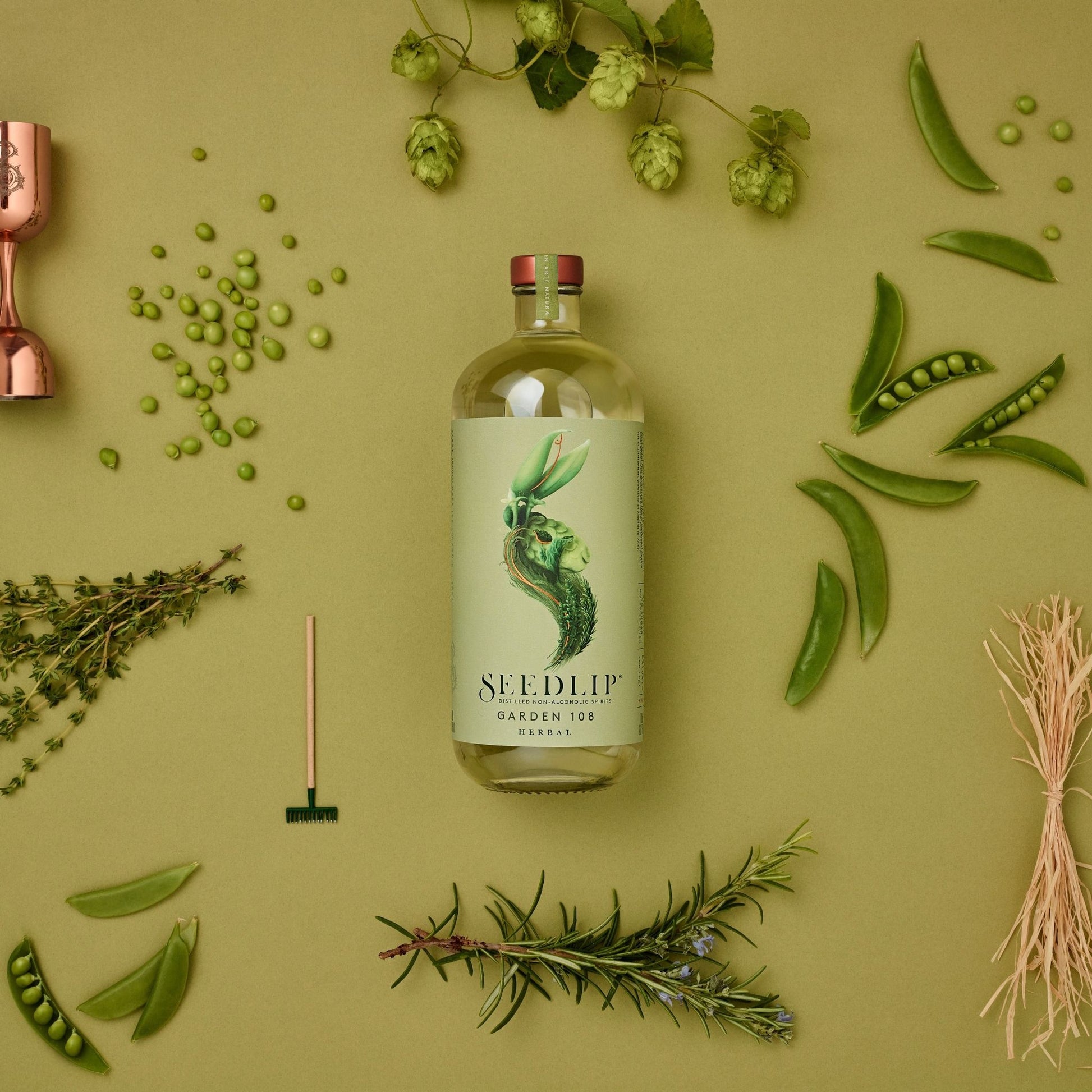 A photo of a 700 milliliter bottle of Seedlip Garden 108 Herbal surrounded by herbs. Seedlip is available for sale at knyota.com