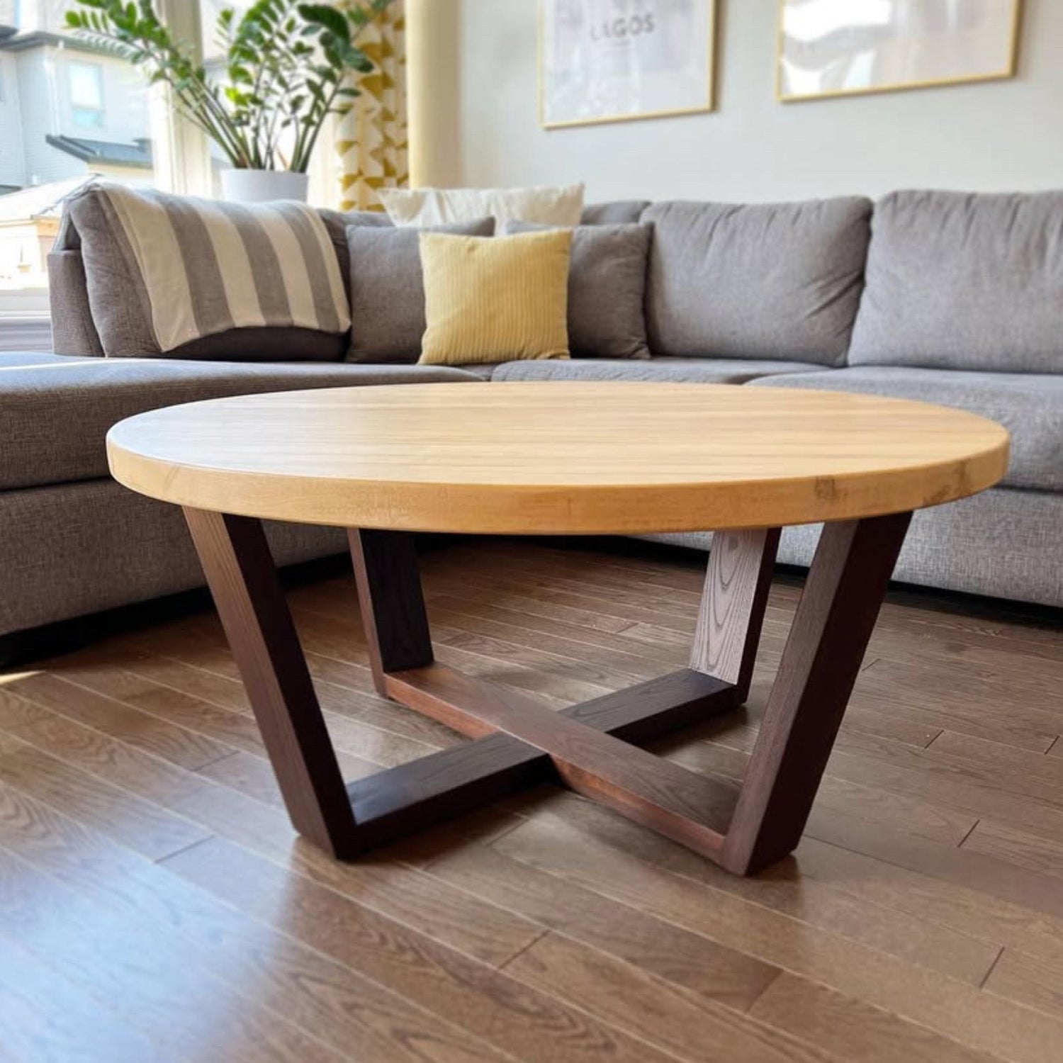 Round coffee table with spalted maple top and torrefied ash geometric base in a modern living room by Milano Woodworking