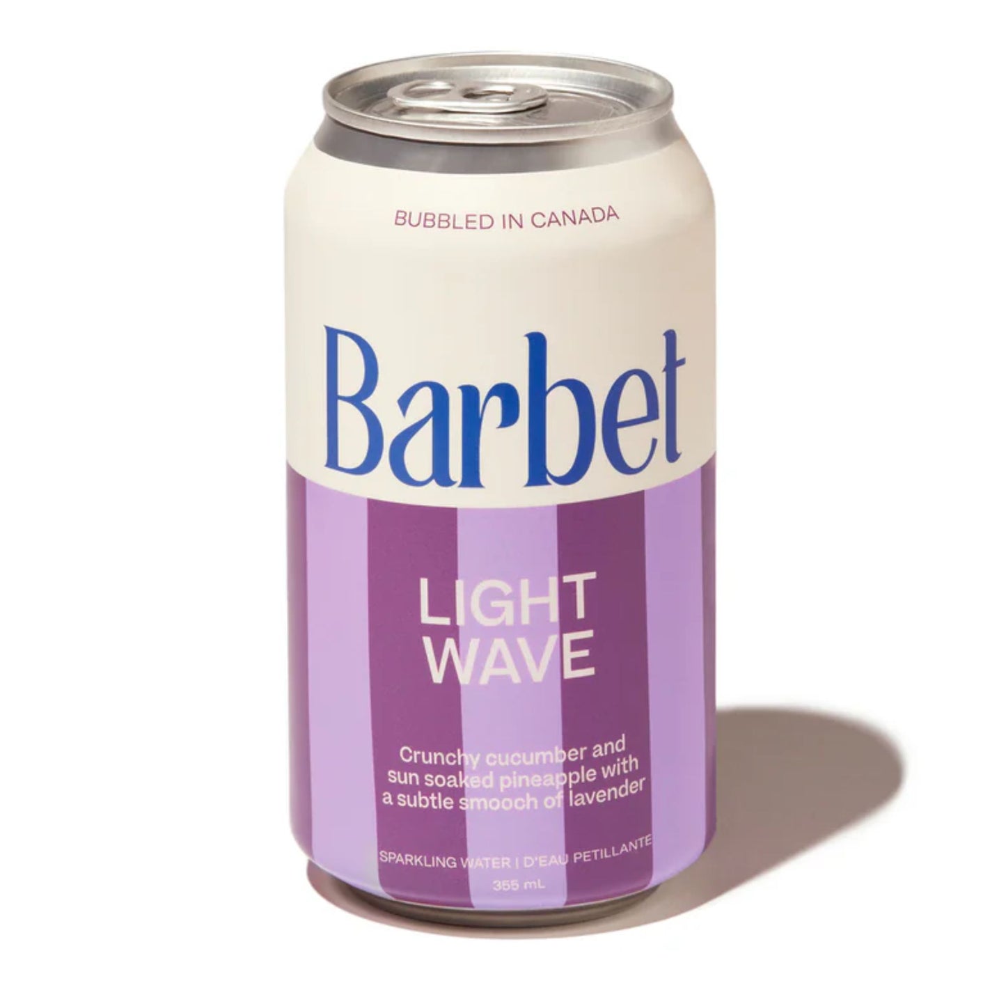 Barbet Light Wave non-alcoholic sparkling water 355mL can on a white background. The can features bold white and lavender purple vertical stripes and the flavor description: "Crunchy cucumber and sun soaked pineapple with a subtle smooch of lavender." The product is Bubbled in Canada.
Available for sale at Knyota Non Alcoholic Drink in Ottawa
