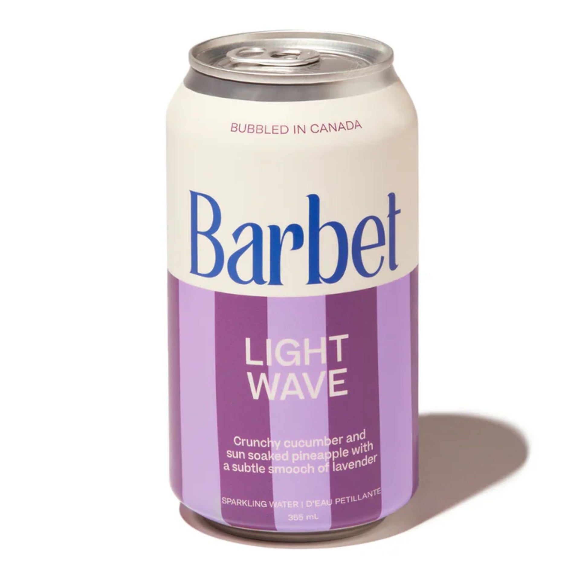 Barbet Light Wave non-alcoholic sparkling water 355mL can on a white background. The can features bold white and lavender purple vertical stripes and the flavor description: "Crunchy cucumber and sun soaked pineapple with a subtle smooch of lavender." The product is Bubbled in Canada.
Available for sale at Knyota Non Alcoholic Drink in Ottawa

