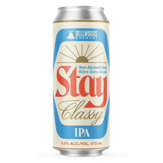 A silver aluminum can of Bellwoods Brewery Non-Alcoholic Beer Stay Classy stands upright against a white background. The can has a cream-colored label with a blue, rounded-edge rectangle in the center. Inside the blue shape, the word "Stay" is written in a stylized red font above "Classy" in a cursive red font. Above "Stay," smaller text reads "Non-Alcoholic Beer Bière Sans Alcool." Above this text is the Bellwoods Brewery logo.