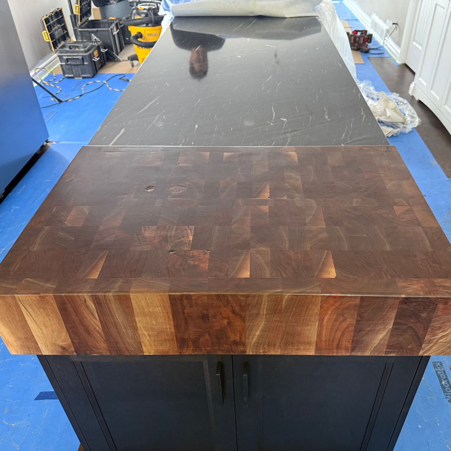 Solid walnut end grain butcher block installed on a black kitchen island with rich geometric wood pattern by Milano Woodworking.