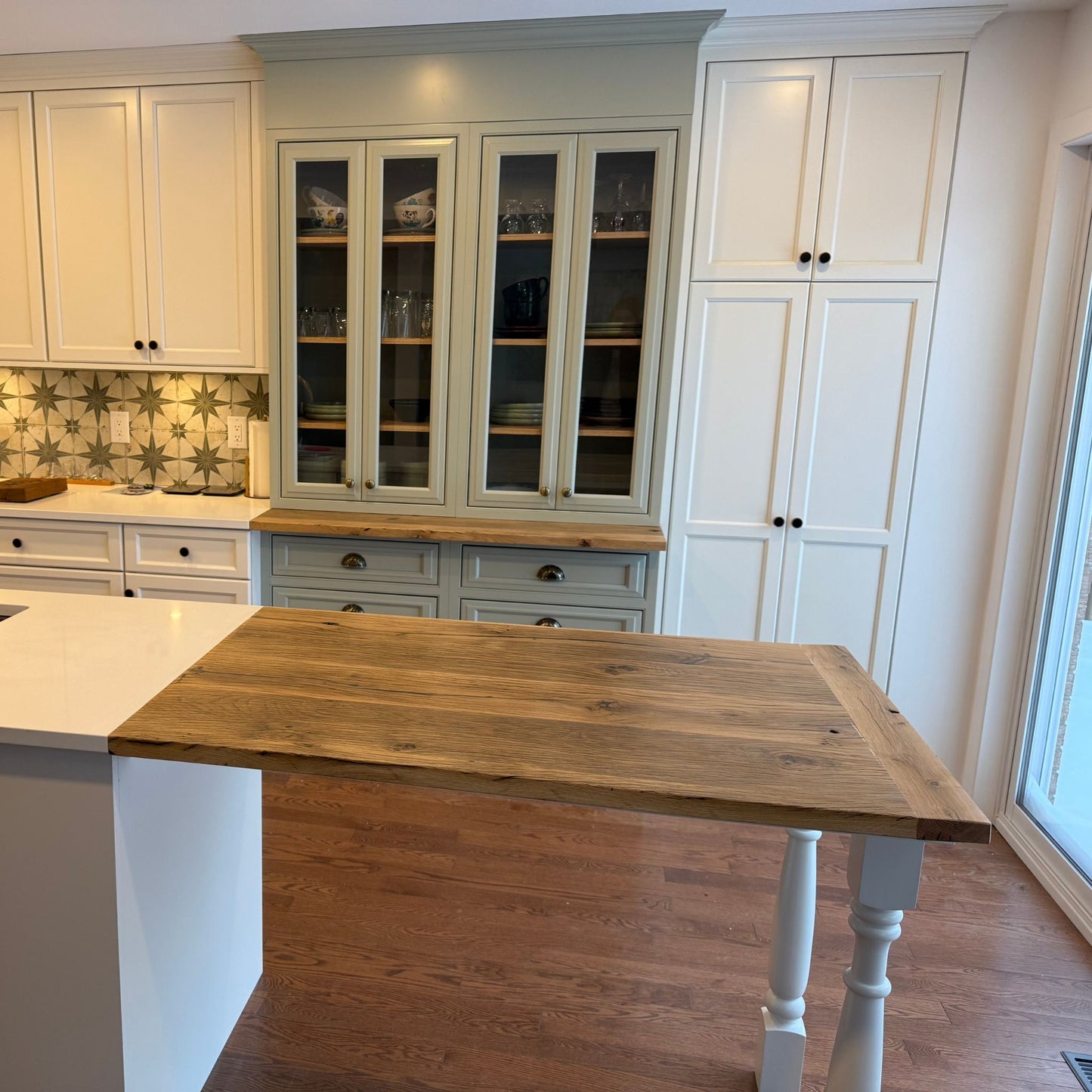 Reclaimed French oak kitchen countertop installed on a white island in a modern kitchen with custom cabinetry by Milano Woodworking