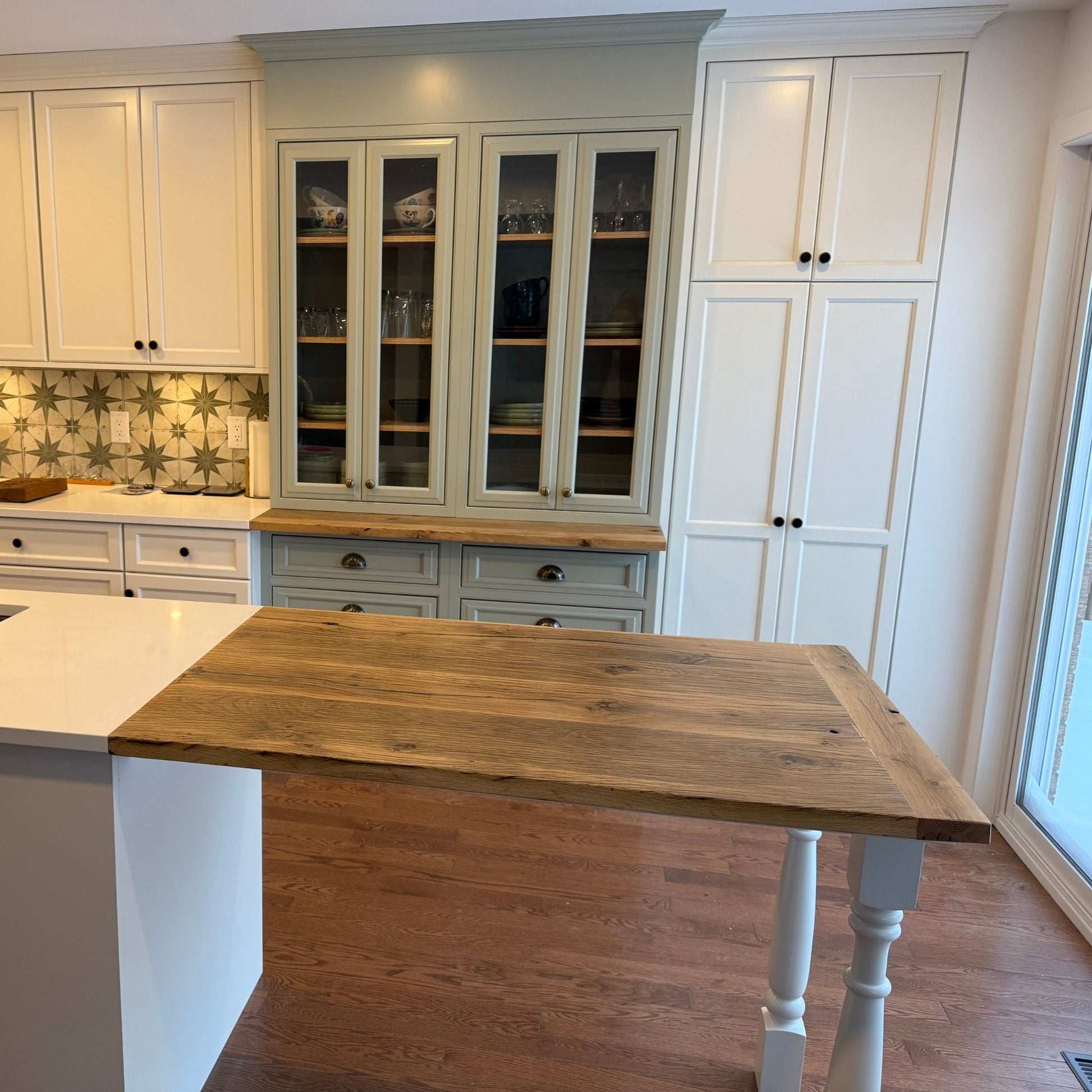 Reclaimed French oak kitchen countertop installed on a white island in a modern kitchen with custom cabinetry by Milano Woodworking